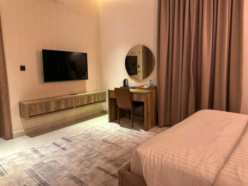 Una televisión o centro de entretenimiento en Elysian Hotels Abuja