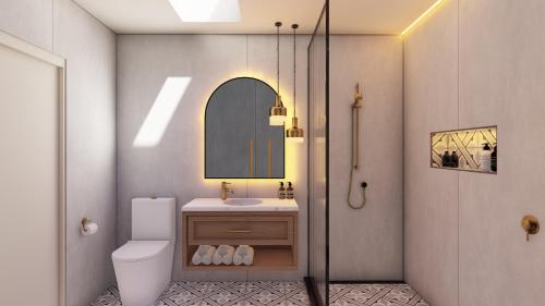 a bathroom with a toilet and a sink and a mirror at The Clements Hotel in Cambridge