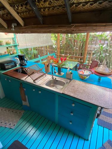 a kitchen with blue cabinets and a sink at Polynesian Bungalow SEASHEL private bath, clim et piscine partagée in Moorea