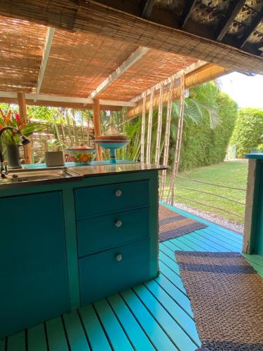 a kitchen under a pergola on a deck at Polynesian Bungalow SEASHEL private bath, clim et piscine partagée in Moorea