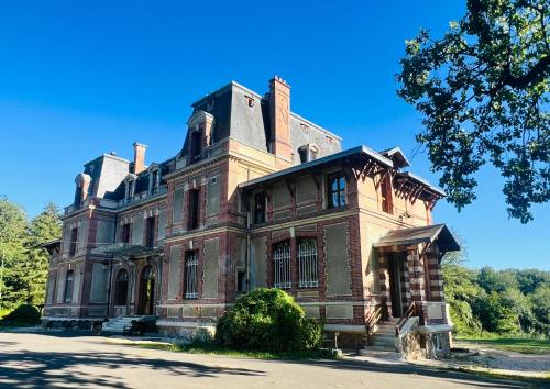 une grande maison en briques avec un toit dans l'établissement Chambre au Château, à Chaumes-en-Brie