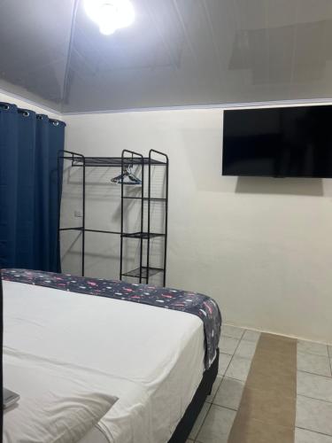 a bedroom with a bed and a tv on a wall at Cabinas Manzanillo Caribe in Manzanillo
