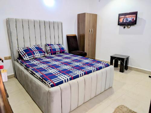 a bedroom with a large bed and a television at White Castle Apartments in Uyo
