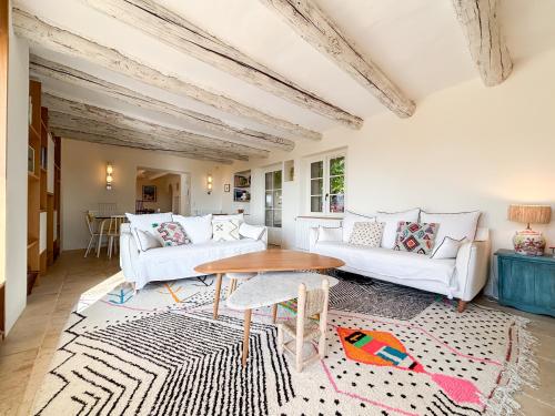 - un salon avec deux canapés blancs et une table dans l'établissement Mas des Collines, à Saint-Hippolyte-le-Graveyron