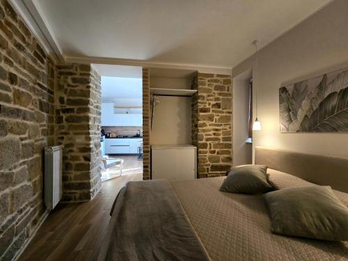 a bedroom with a bed and a brick wall at La Stella del Viandante in Pietrapertosa