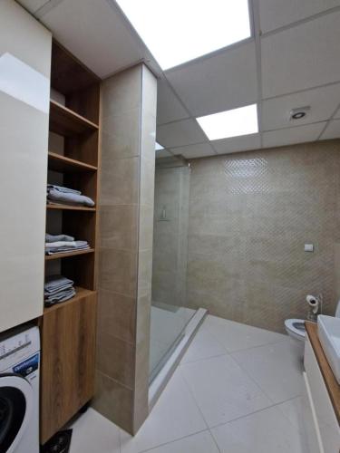 a bathroom with a shower and a washing machine at Petreski Apartments 1 in Ohrid