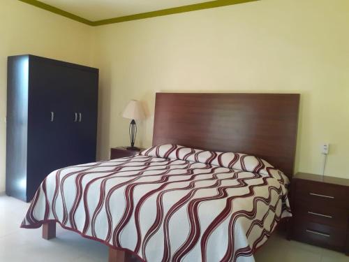 a bedroom with a large bed with a wooden headboard at Casa Quetzal in Peñita de Jaltemba