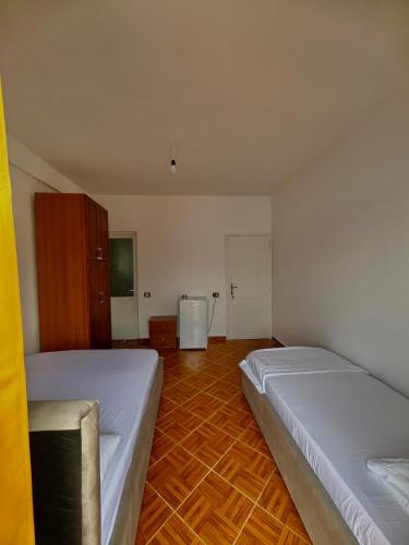 a bedroom with two beds and a wooden floor at Room with amazing sea view in Himare