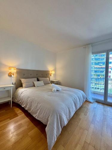 une chambre avec un grand lit et une grande fenêtre dans l'établissement Stunning sea views, full sun exposure, à Nice