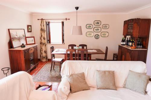 a living room with a white couch and a table at Casa da Chitas in Ponte de Lima