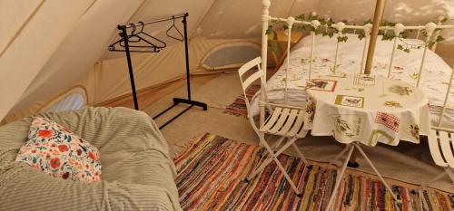 a room with a bed and a table in a tent at Koppány Pines - Bell Tent B & B Rooms in Koppányszántó