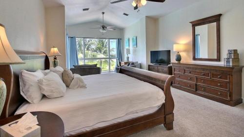 a bedroom with a large bed and a television at 411 Mariners Club in Key Largo