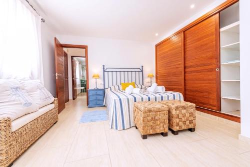 a bedroom with a bed and a couch in a room at Villa Azumar, piscina, jardín in Sant Carles de Peralta