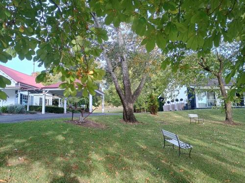 a park bench in the grass in front of a house at Moore Park Inn in Armidale