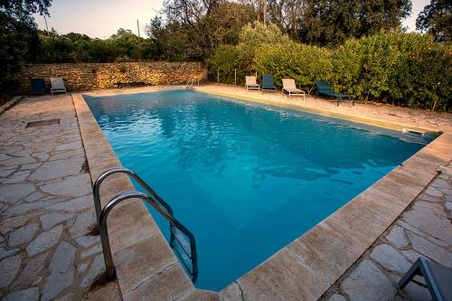 une grande piscine avec des chaises dans une cour dans l'établissement Mas des Collines, à Saint-Hippolyte-le-Graveyron
