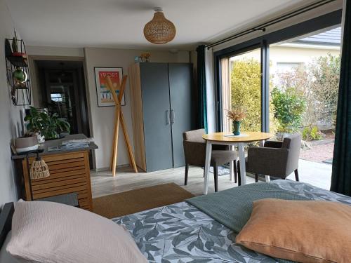 une chambre avec un lit, une table et une fenêtre dans l'établissement Le Cottage de l'Albâtre Gîte 2 pers jardin parking à Vattetot sur Mer, à Vattetot-sur-Mer