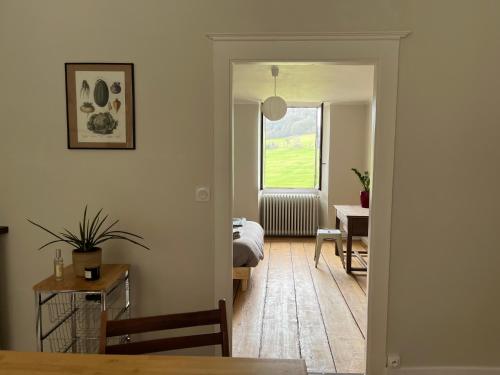 a living room with a bed and a table at Maison de campagne avec vue exceptionnelle in Abbans-Dessus