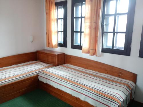 two beds in a room with two windows at Кедър 5 in Dolna Banya