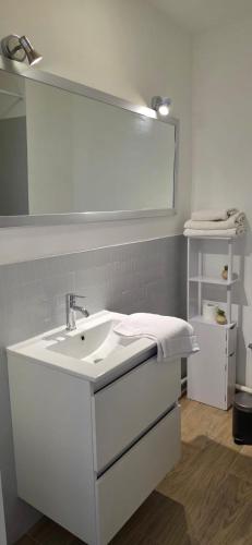 une salle de bain avec un lavabo blanc et un miroir dans l'établissement Joli appart Carnon parking Free, wifi 7Min Airport, à Carnon-Plage