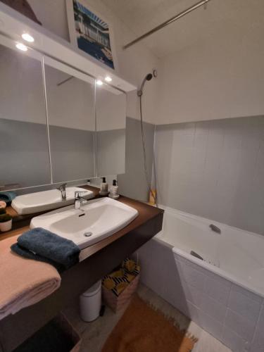 une salle de bain avec un lavabo et une baignoire dans l'établissement COSY STUDIO BENODET vue mer accès direct plage Thalasso Casino, à Bénodet
