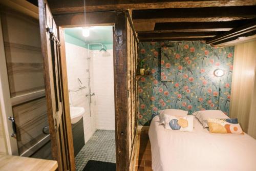 a small bedroom with a bed and a bathroom at Le Refuge d'Alfred, centre Pont-Audemer in Pont-Audemer