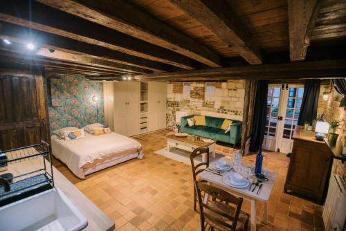 a bedroom with a bed and a table and a couch at Le Refuge d'Alfred, centre Pont-Audemer in Pont-Audemer