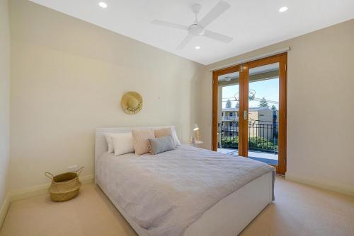 a bedroom with a large bed and a large window at Aria House - Henley Beach - Family Holiday Beachside BBQ in Henley Beach