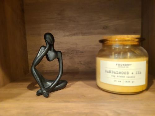 a small statue of a person standing next to a jar at PNW Creekside Escape Relax, Unwind, Explore in Marysville