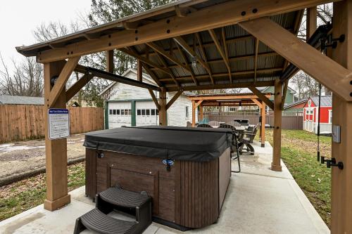 a wooden pergola with a hot tub and a table at Berrodin Bed & Breakfast in Akron
