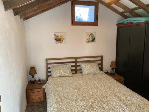a bedroom with a bed with two pillows and a window at Bodega Linda in Puntagorda