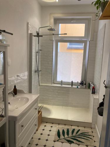 a bathroom with a sink and a shower and a window at Zentrales Zimmer mit eigenem Balkon in Hamburg