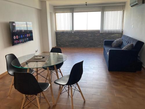 a living room with a glass table and chairs at Lecheria con vista al mar in Morro de Barcelona
