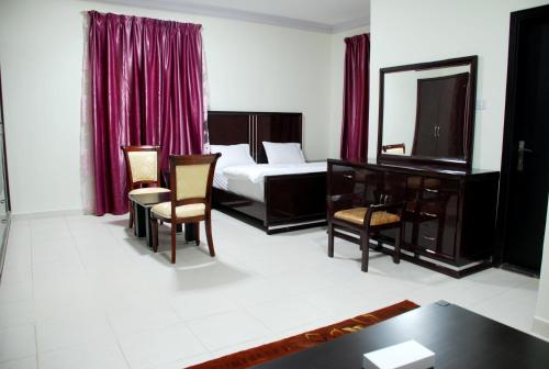 a bedroom with a bed and a table and chairs at Paradise Inn Hotel (Tabasum Group) in Ajman 