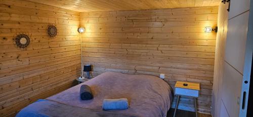 a small bedroom with a bed in a wooden wall at ANA Belle chambre in Saint Paul de Vence