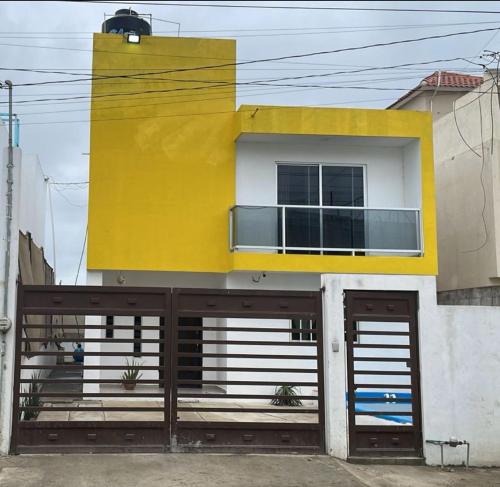 a yellow and white building with two garage doors at Casa SOL in Cobos
