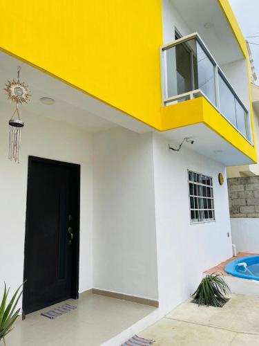 a house with a black door and a yellow balcony at Casa SOL in Cobos