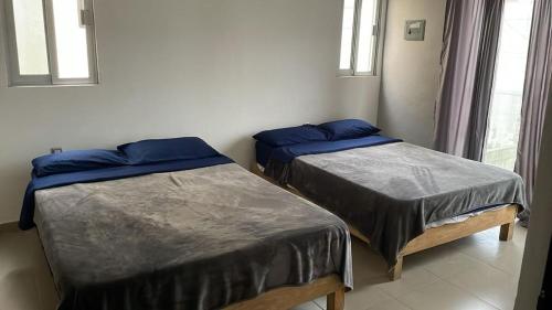 two beds in a room with two windows at Casa SOL in Cobos