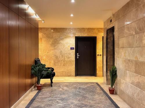 a hallway with a door and a chair in front of it at Quiet Rooms 12 in Riyadh