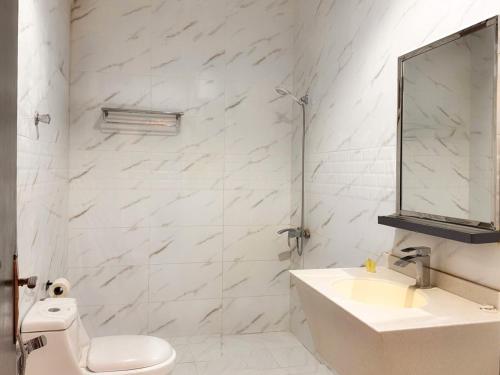 a white bathroom with a sink and a mirror at Quiet Rooms 12 in Riyadh