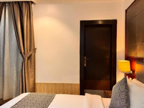 a bedroom with a bed and a black door at Quiet Rooms 12 in Riyadh