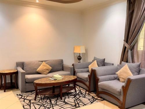 a living room with two couches and a table at Quiet Rooms 12 in Riyadh