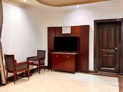 a living room with a tv and a table and chairs at Quiet Rooms 12 in Riyadh