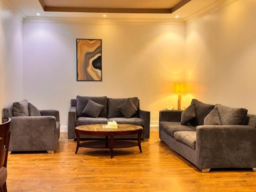 a living room with two couches and a coffee table at Quiet Rooms 12 in Riyadh