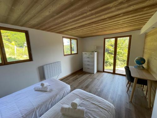 - une chambre avec 2 lits, un bureau et des fenêtres dans l'établissement Chalet les brimbelles, à Le Tholy
