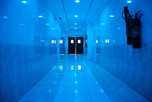 a hallway with blue lights and a door at Paradise Inn Hotel (Tabasum Group) in Ajman 