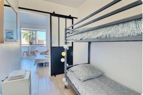 Cet appartement comprend une chambre avec deux lits superposés et un salon. dans l'établissement Appartement Instant Cozy Proche Mer avec Parking, à La Ciotat