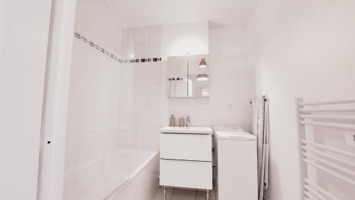Un baño blanco con bañera y lavabo. en Le Gabrielle-Charmant Appartement-Parking, en Rouen