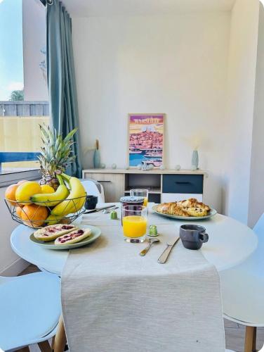 - une table avec de la nourriture et un verre de jus d'orange dans l'établissement Appartement Instant Cozy Proche Mer avec Parking, à La Ciotat