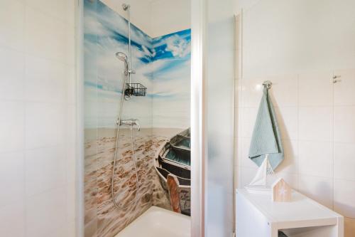 La salle de bains est pourvue d'une douche et d'une peinture représentant une voiture. dans l'établissement Ferienwohnung Fachwerkhaus - Westen unten - Bauernhof Hopp Vadersdorf, à Fehmarn
