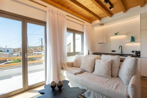 a living room with a couch and a large window at Acres Luxe, First Floor Haven & Ground Floor Retreat in Ano Mera